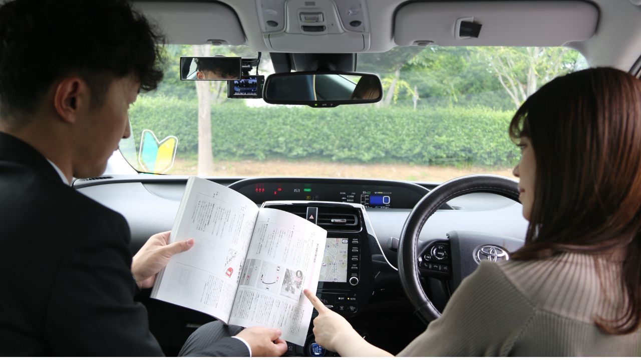 助手席からお客様の運転をサポートするインストラクター