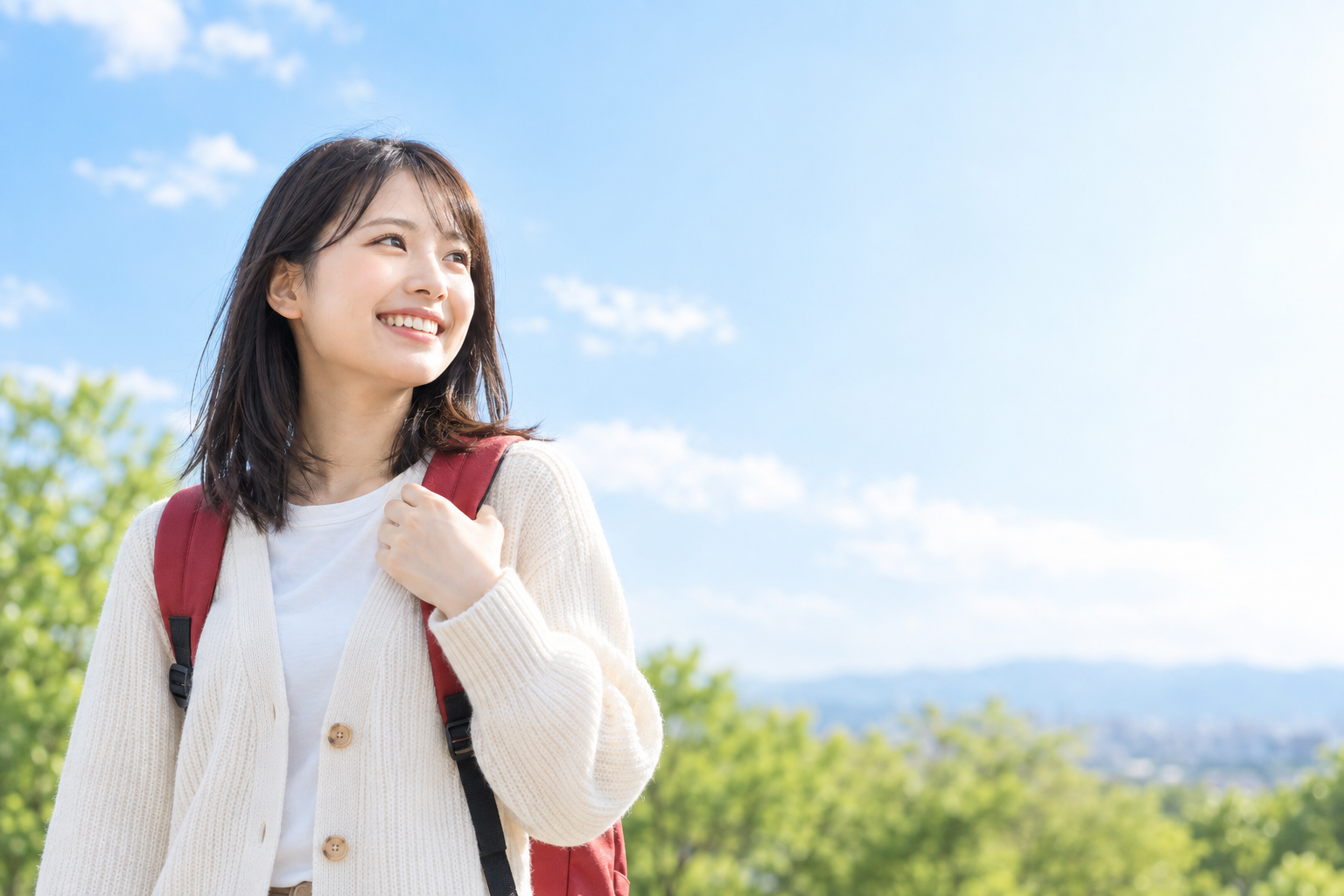 青空の下、リュックを背負って出発する学生のイメージ